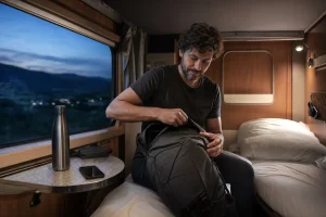 Viaggiatore sistema il bagaglio in una cuccetta di un treno notturno